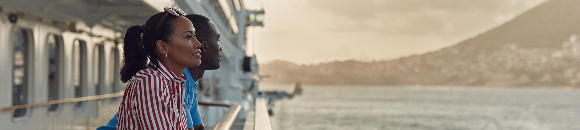 Couple on deck looking out at the passing scenery on a Crystal cruise ship